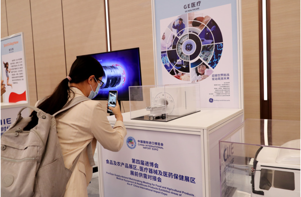 第四屆進(jìn)博會食品及農(nóng)產(chǎn)品展區(qū)、醫(yī)療器械及醫(yī)藥保健展區(qū)展前供需對接會的參會嘉賓用手機(jī)拍攝參展企業(yè)的展品模型